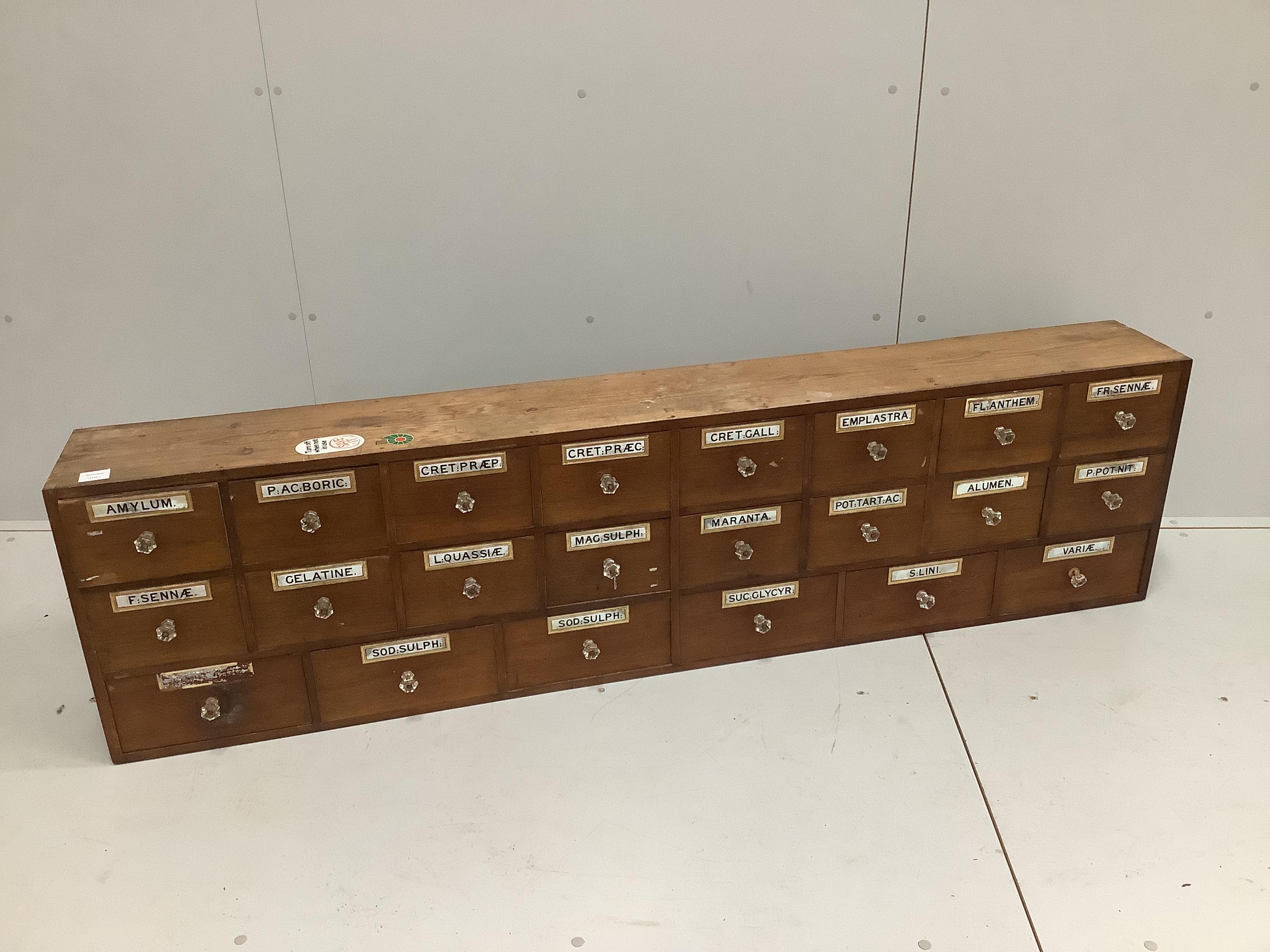 A nest of pine pharmacist's drawers, width 183cm, height 49cm